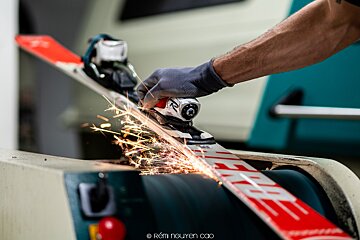 A person is sharpening a ski with the word free on it