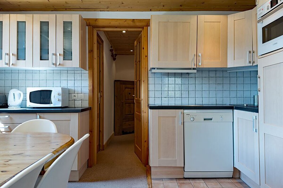 A kitchen with white cabinets and a bosch dishwasher
