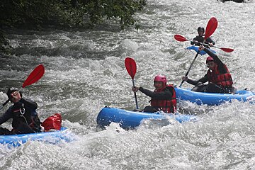 people rafting on canoes on a river