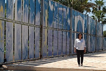 a woman stood next to some art in the gardens of a hotel