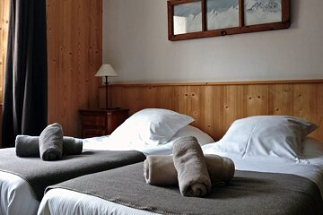 Two beds with towels on them in a hotel room