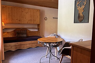 A room with a wooden bed and a wooden table