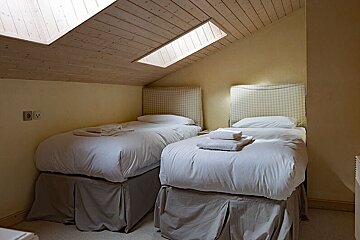 A bedroom with two twin beds and a skylight