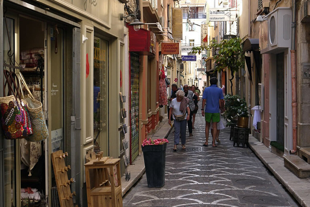 People walking down a narrow street with a sign that says librairie