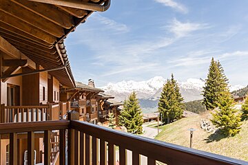 A balcony with a view of mountains and trees