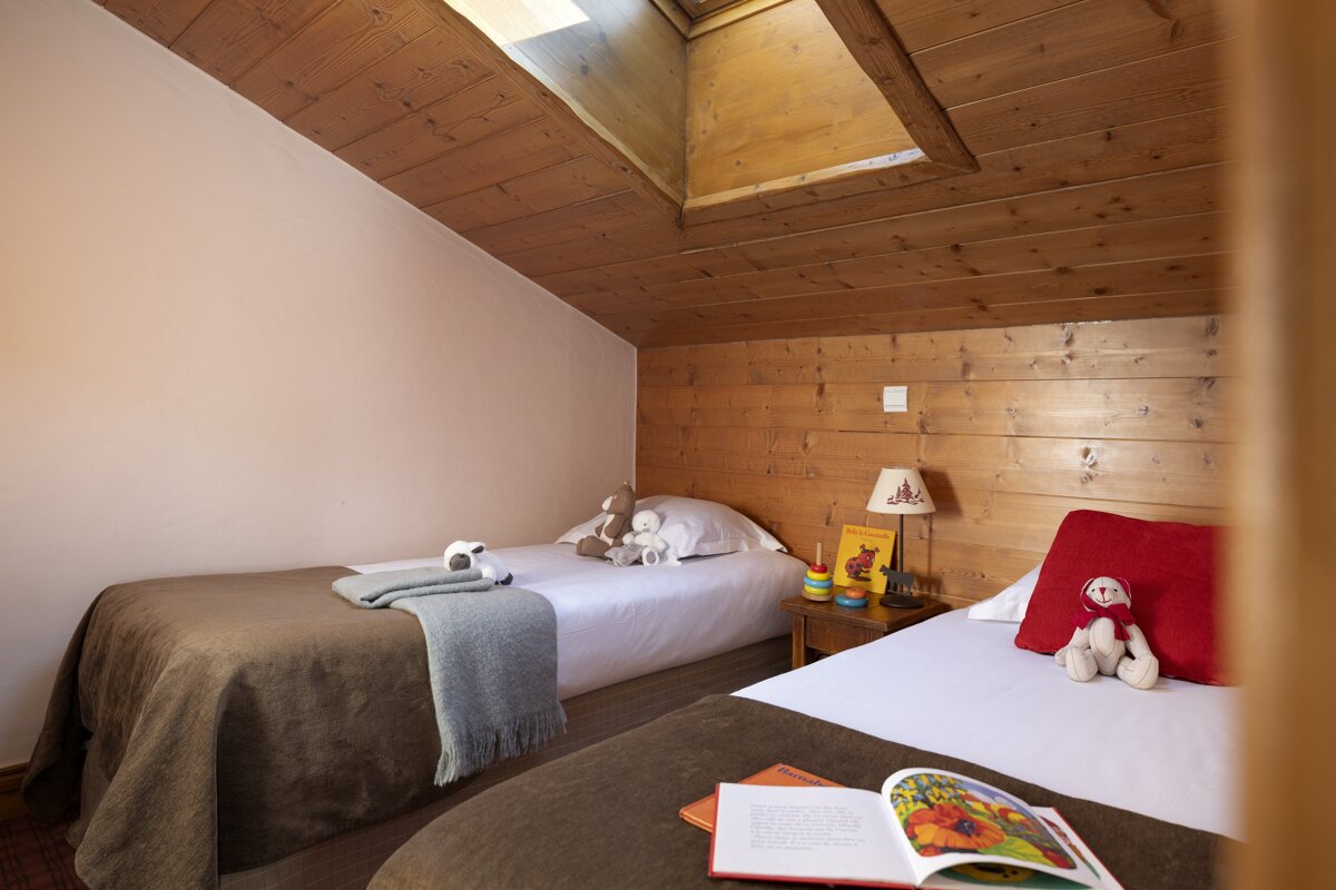 A bedroom with two beds and a book on the bed