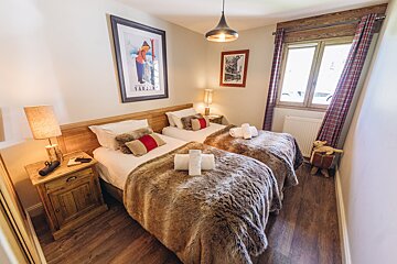 A bedroom with two beds and a picture of a skier on the wall