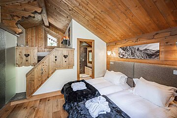 A bedroom with two beds and a picture of mountains on the wall