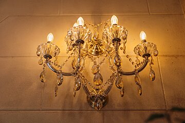 A chandelier hanging on a wall with candles on it