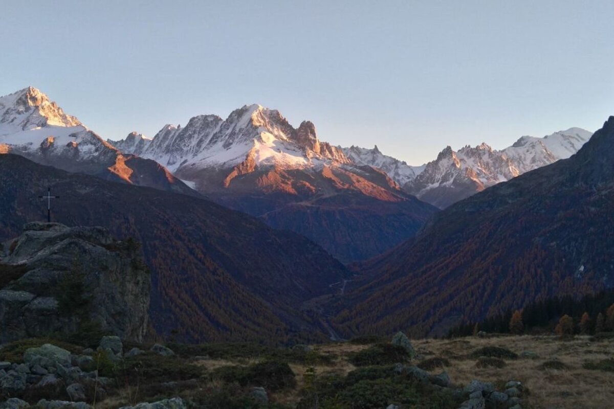 A mountain range with a cross in the foreground
