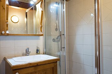 A bathroom with a sink and a shower stall