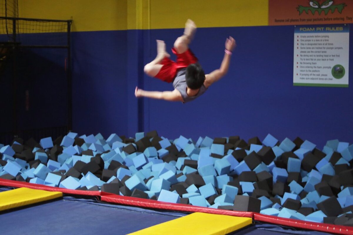 a man jumping off a trampoline