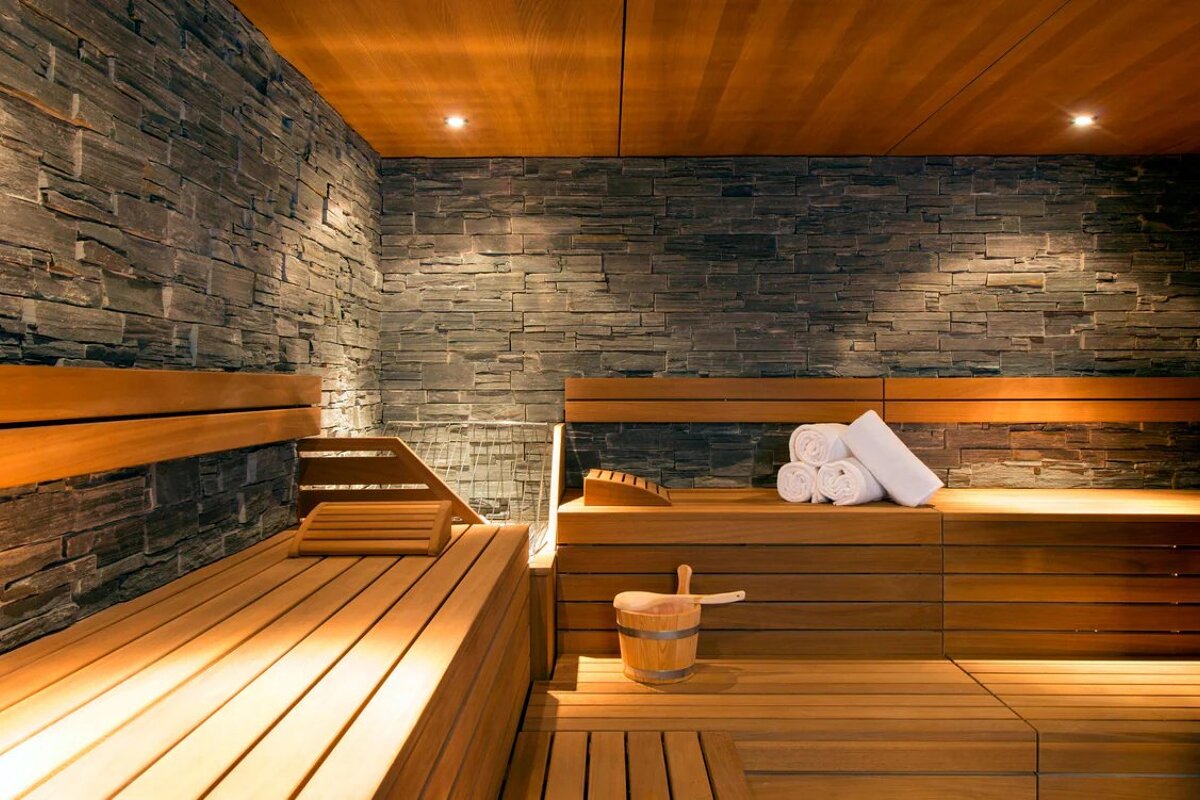 A wooden sauna with a bucket and towels on the benches