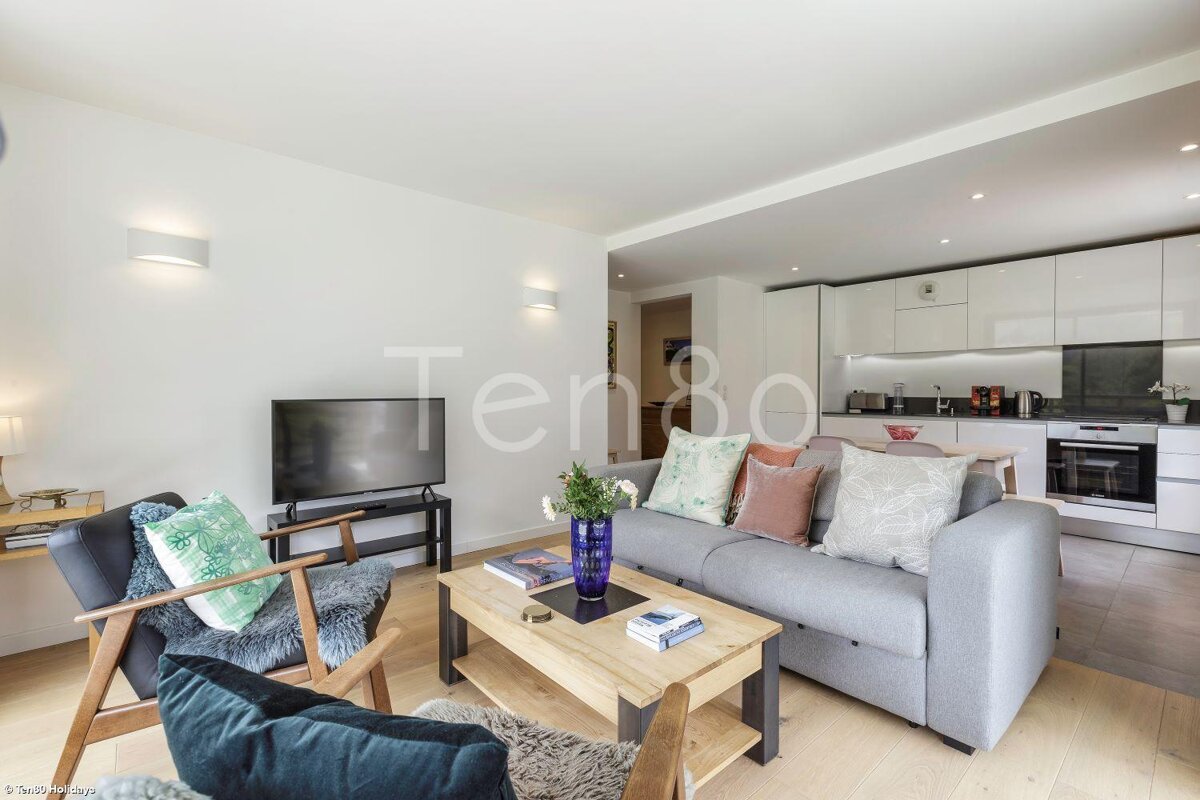 A living room with a gray couch and a flat screen tv