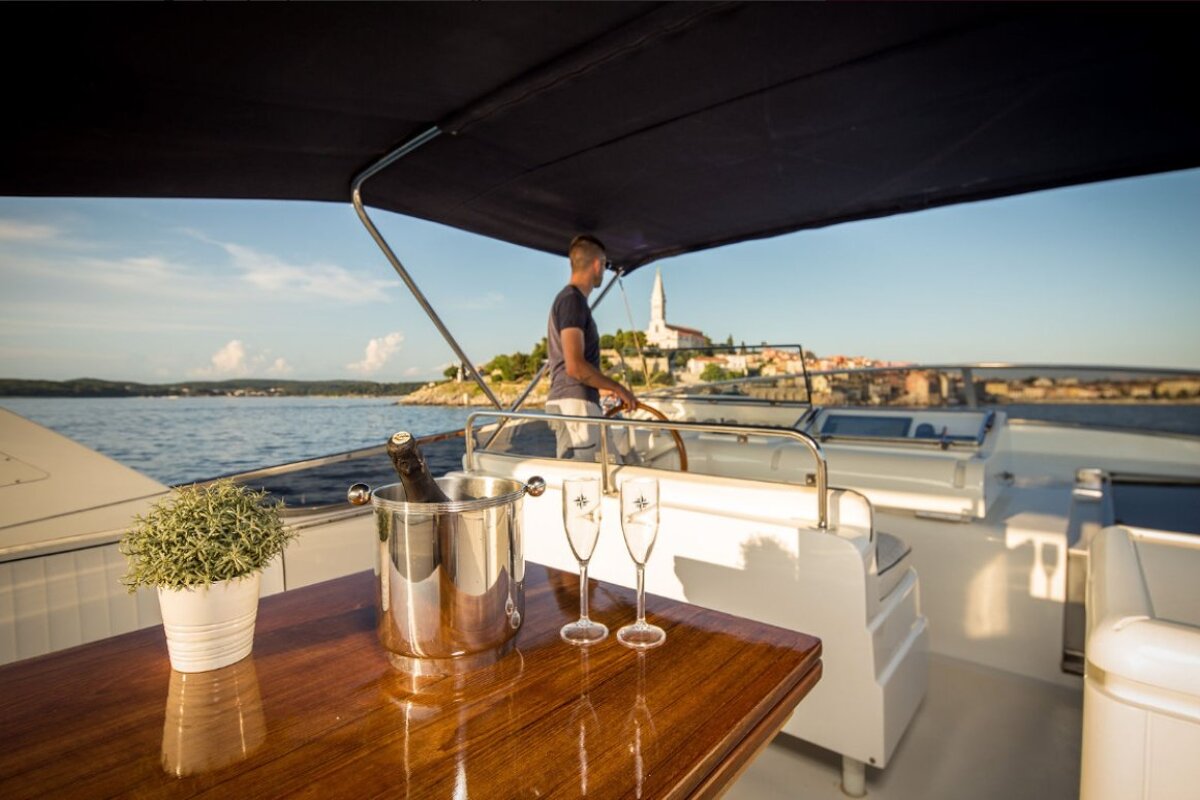 A man on a boat with a bucket of champagne and two glasses