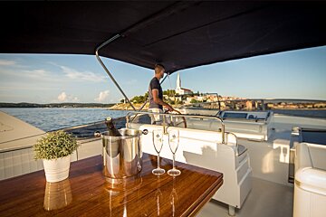 A man on a boat with a bucket of champagne and two glasses