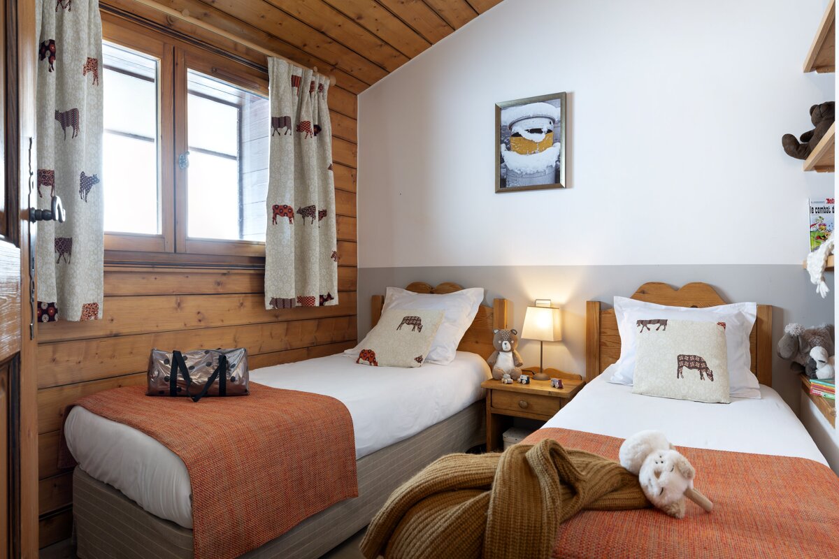 A bedroom with two beds and a picture on the wall