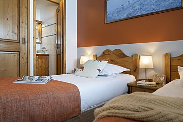 A bedroom with two beds and a picture on the wall