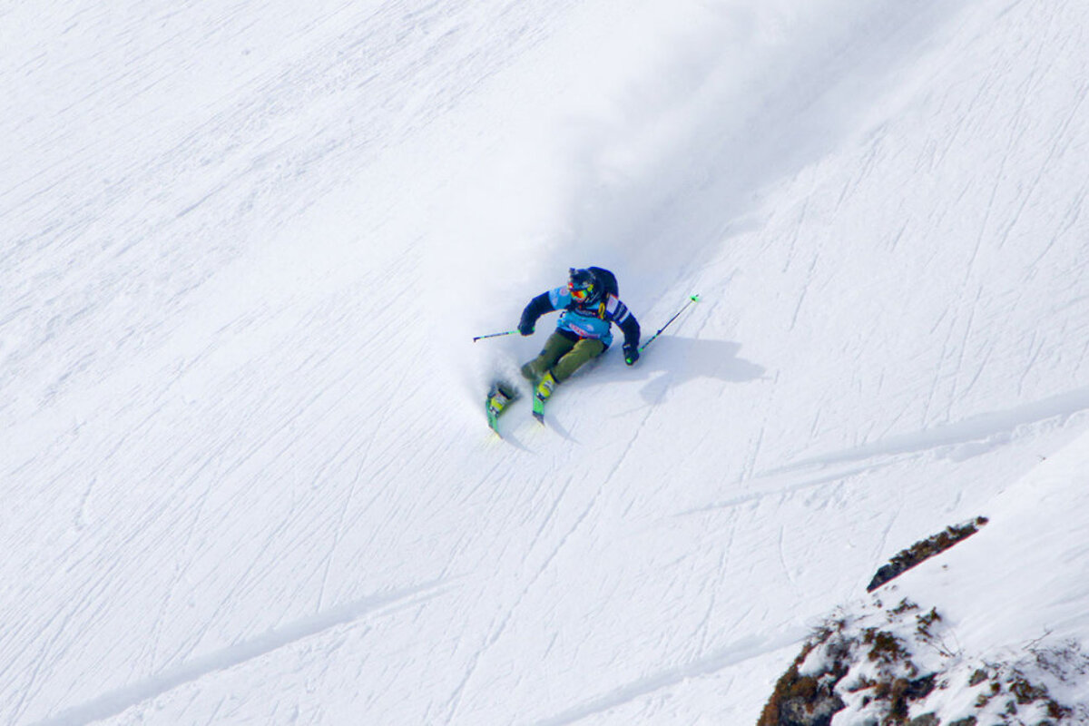 a skier in steep powder turn