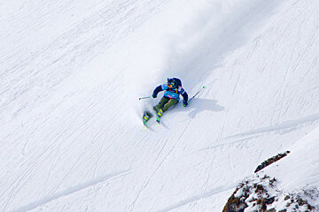 a skier in steep powder turn