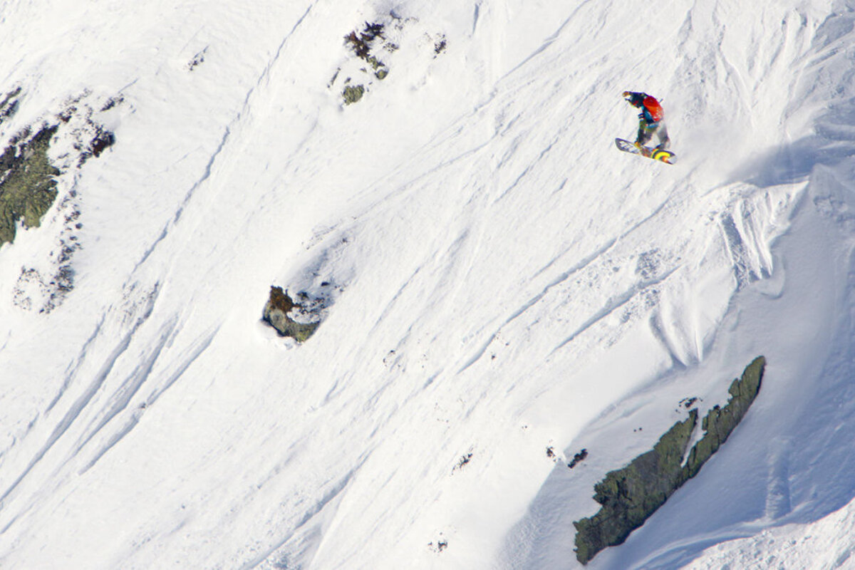 snowboarder grabbing his board
