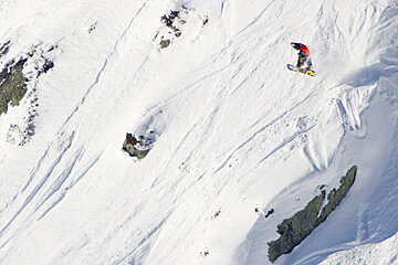 snowboarder grabbing his board