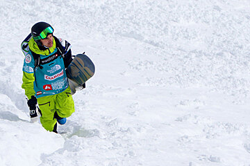 snowboarder holding board and hiking up