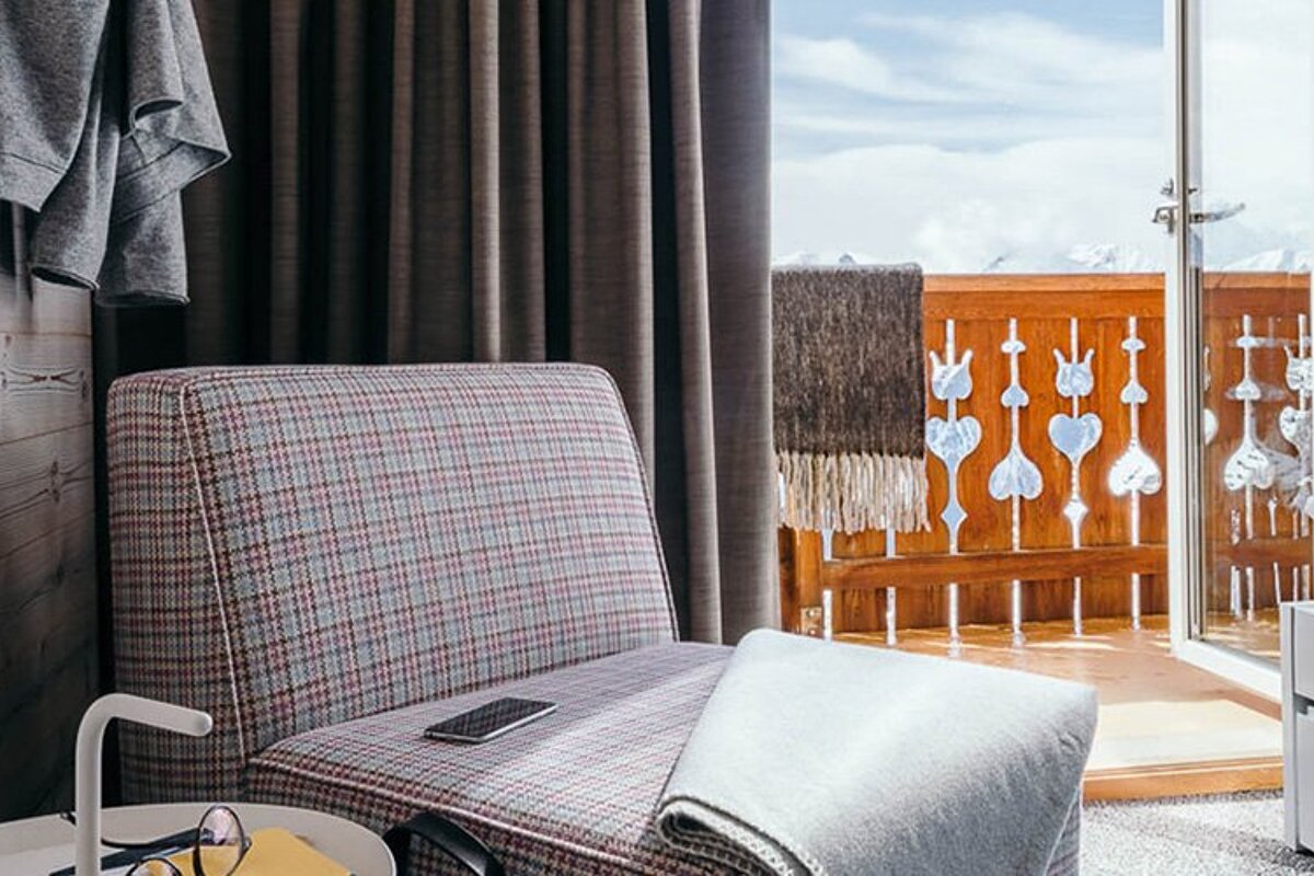 A chair with a cell phone on it sits in front of a balcony