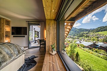 A living room with a view of a valley and mountains