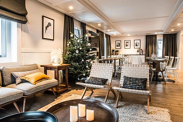 A living room with a christmas tree in the background