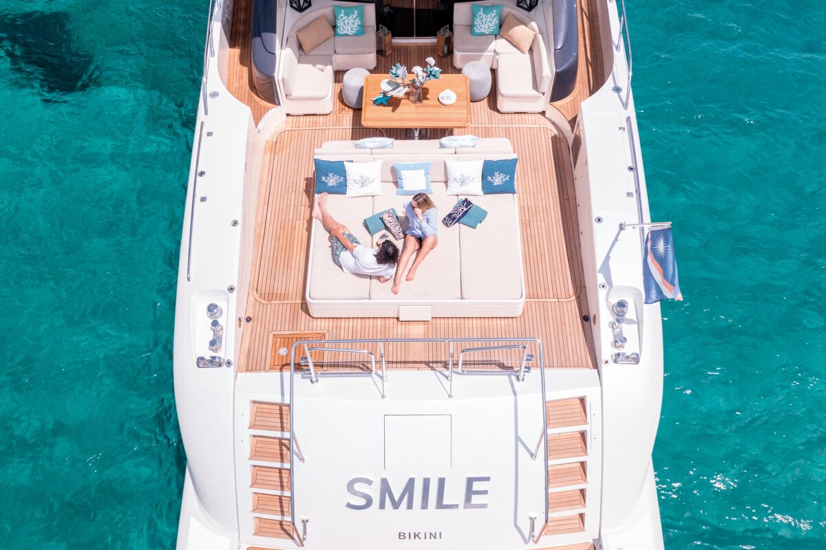 A white yacht with smile bikini written on the side