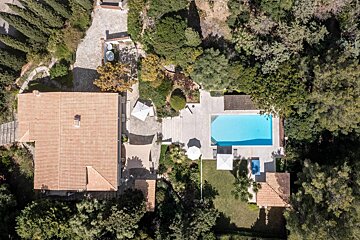 An aerial view of a house with a large pool