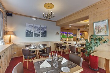 A dining room with tables and chairs and a chandelier
