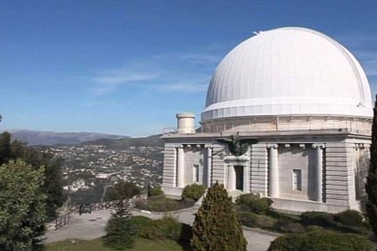 A large dome on top of a building with a city in the background