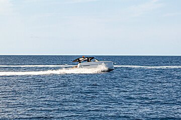 A white boat is floating on top of a large body of water