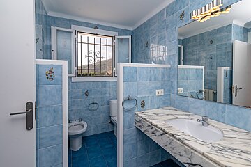 A bathroom with blue tiles and a sink