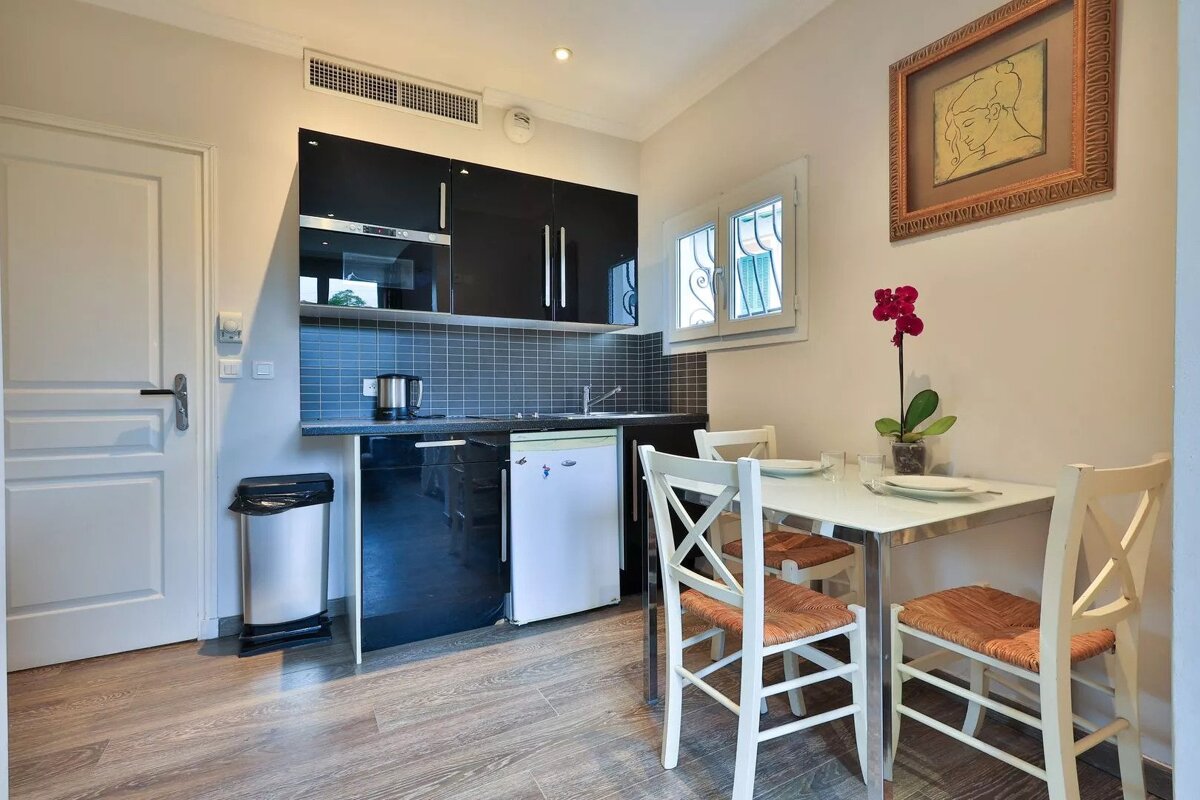 A kitchen with a table and chairs and a picture on the wall