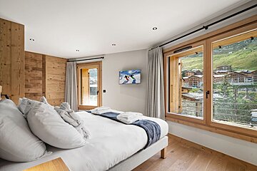 A bedroom with a painting of skiers on the wall