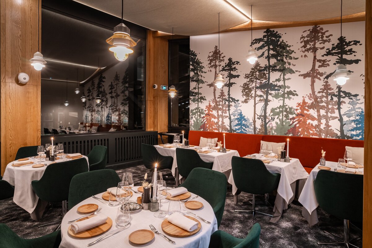 A dining room with white tables and green chairs