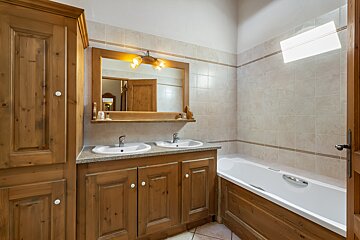 A bathroom with two sinks and a bathtub