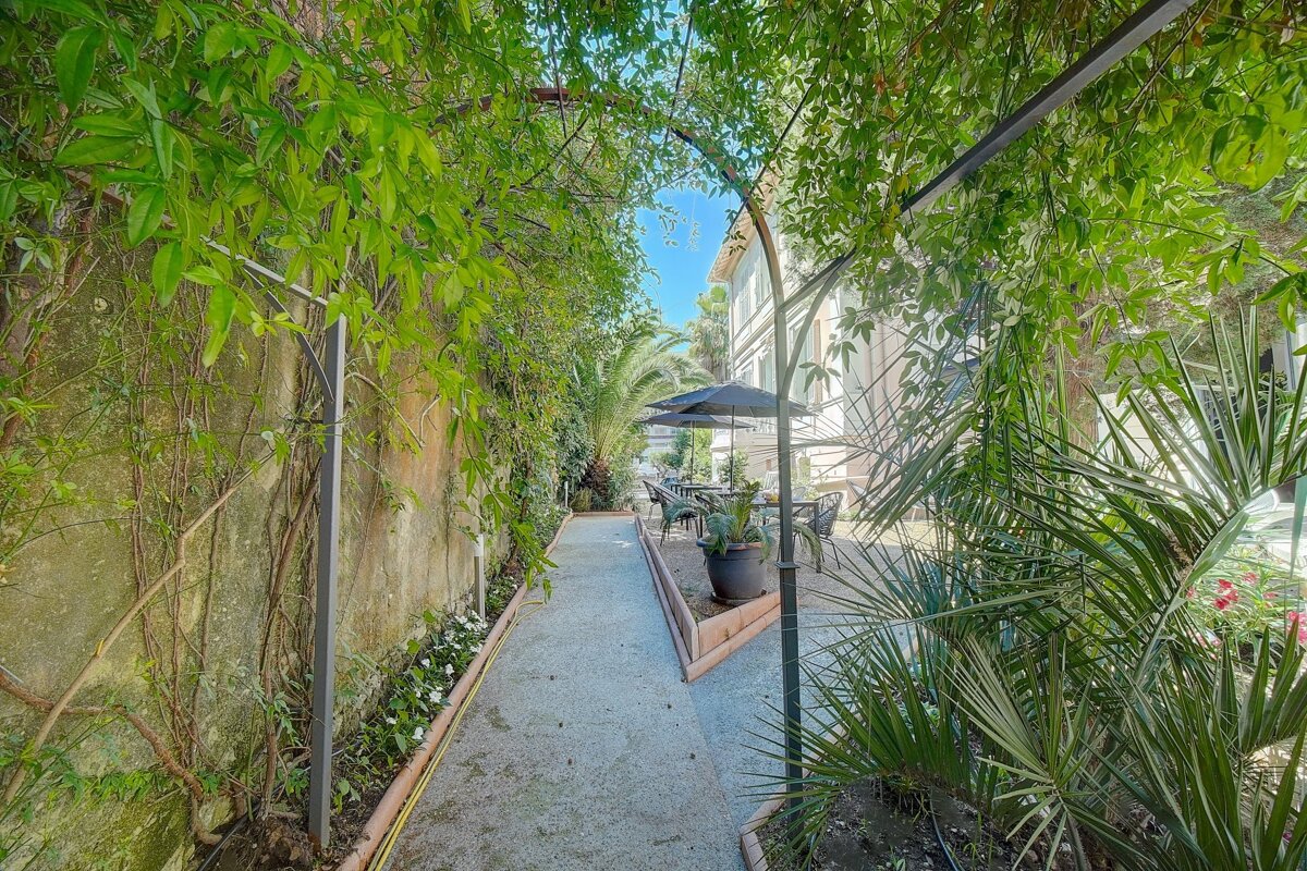 A narrow path leading to a patio with umbrellas