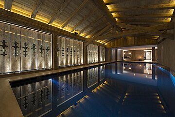 A large indoor swimming pool with a wooden ceiling
