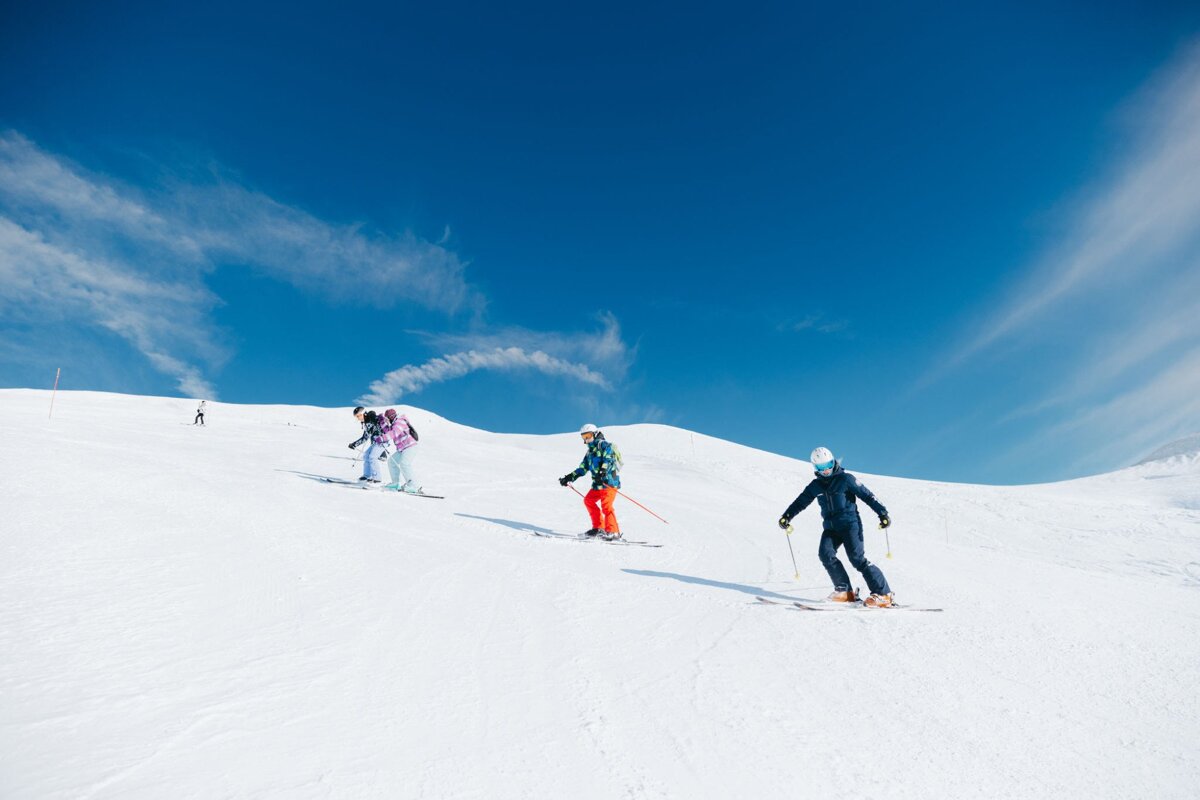 A group of people skiing down a snow covered slope
