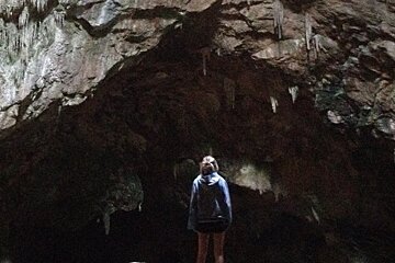 a girl staring into a cave in Mallorca