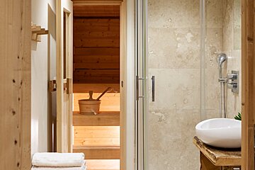 A bathroom with a wooden sauna and a white sink