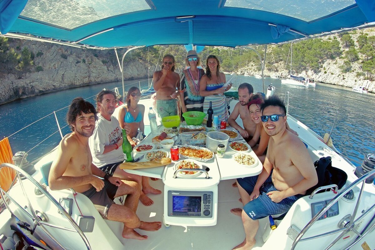 A group of people are sitting around a table on a boat