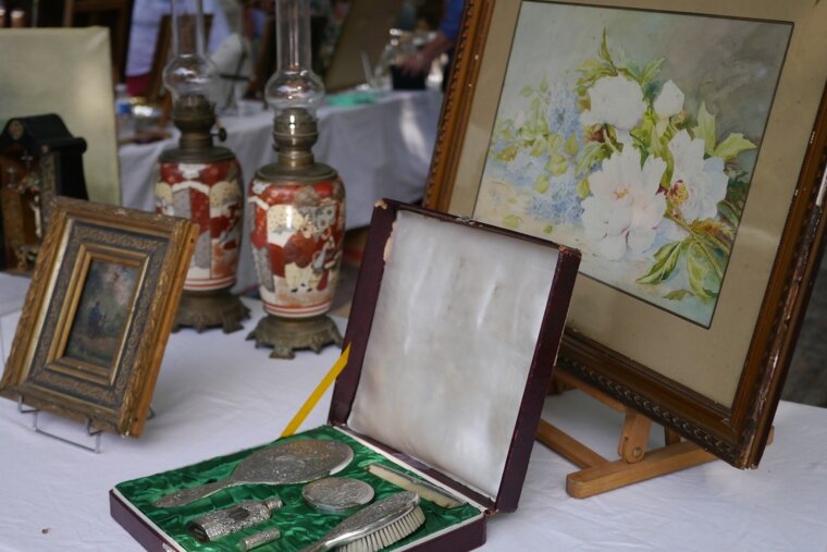 A box with a mirror and brush sits on a table next to a painting