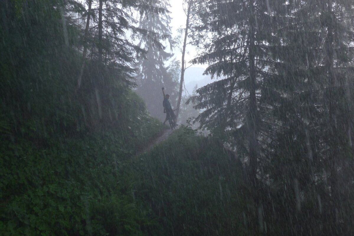 a distant mountain biker raising his fist in the rain