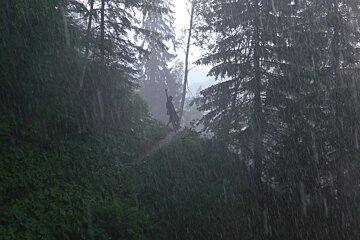 a distant mountain biker raising his fist in the rain