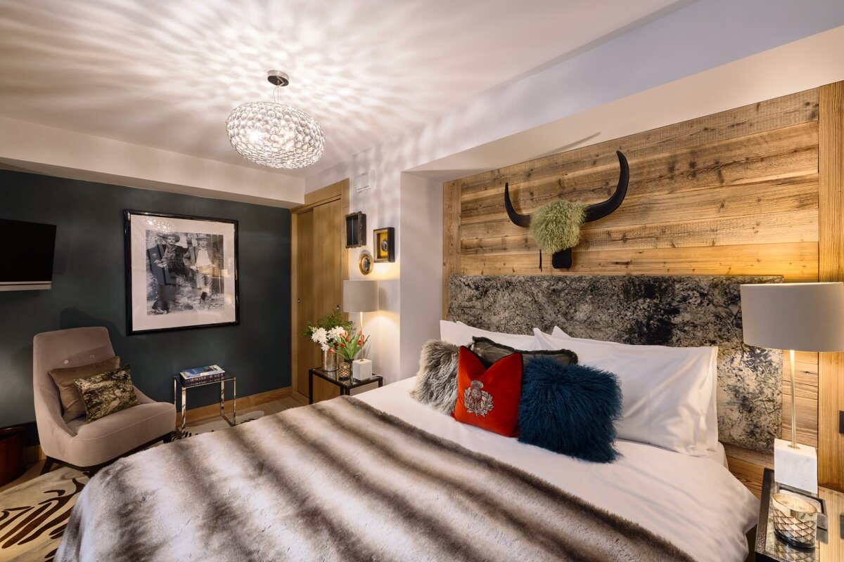 A bedroom with a bed a chair and a picture on the wall